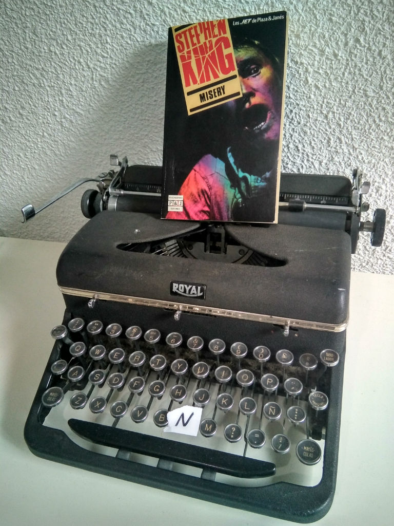 Libro Misery de Stephen King sobre una máquina de escribir "Royal", sin la letra N en su teclado.